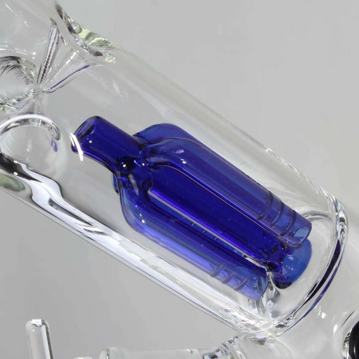 Glass bong with a blue piece on a gray background